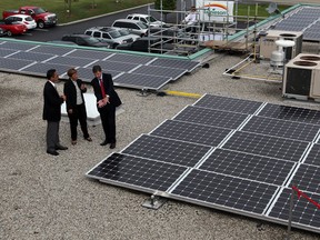 From L: Peter Goodman, CEO of Solar Power Network; Windsor West MPP Teresa Piruzza; and Ontario Minister of Energy Chris Bentley examine solar panels on the roof of Jamieson Laboratories in Windsor, Ont. Photographed July 31, 2012. (Nick Brancaccio / The Windsor Star)