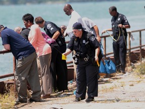 Detroit homicide investigators, patrol officers and dive team members investigate the crime scene following the discovery of body parts from at least two people in the Detroit river in Detroit. (JASON KRYK/ The Windsor Star)