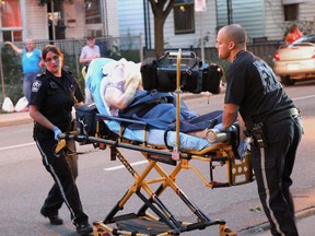 WINDSOR, ONT., July 21, 2012 -- Windsor EMS workers take a woman to the hospital after she suffered burn injuries to her face and arm as a result of a kitchen fire at Thompson Tower apartment building located at 495 Glengarry Ave. on Saturday, July 21, 2012. (REBECCA WRIGHT/ The Windsor Star)