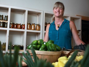 Katie Robinson, owner of The Twisted Apron restaurant, and now The Twisted Apron General Store, is pictured with fresh produce and a wall full of preserved goods at the The Twisted Apron General Store, Saturday, July 21, 2012.  (DAX MELMER/The Windsor Star)