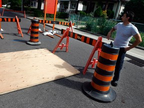 Pierre Avenue resident John Mazza stands by the covered mouth of a sinkhole on his street in Windsor, Ont. Photographed July 23, 2012. (Nick Brancaccio / The Windsor Star)