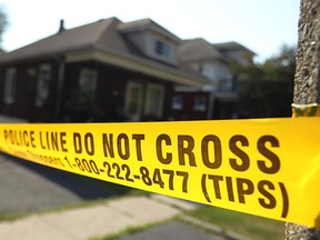 Police tape blocks the sidewalk at the scene of a murder on Oak Avenue in Windsor, Ont. on Thursday, July 13, 2012. A 63-year-old woman was found with stab wounds in the house. Police have charged her son with first-degree murder. (The Windsor Star / TYLER BROWNBRIDGE)