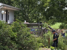 An OPP officer inspects the house where a standoff between a man barricaded in a house and the OPP took place on 16 Mersea Road in Leamington, Sunday, July 8, 2012.   (DAX MELMER/The Windsor Star).