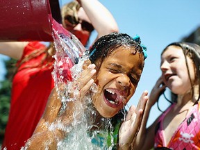 WINDSOR, ONT.: JULY 19, 2011 -- Dezirai Lewenza has a bucket of water poured over her head by a camp counsellor while at the YMCA of Windsor/Essex County Focus on Youth day camp in front of Prince Edward public school in Windsor, Ont., Tuesday, July 19, 2011.   (DAX MELMER / The Windsor Star)