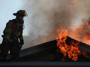 A firefighter battles a blaze on the 1000 block of Albert Road, Saturday, August 25th, 2012.  Three different houses were damaged in the blaze that broke out early Saturday morning.  (DAX MELMER/The Windsor Star)