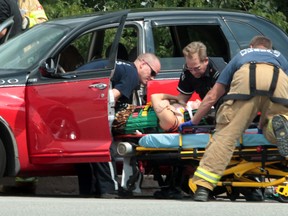 Windsor-Essex EMS paramedics and Windsor firefighters assist in removing a victim of a two-vehicle accident on Riverside Drive west at Curry Avenue in Windsor, Ontario on August 13, 2012.   One patient was transported to hospital with unknown injuries following the collision between a Chrysler PT Cruiser and a Chrysler 200.   Windsor Police are investigating.
