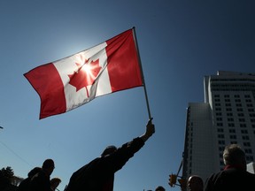 A union supporter waves a Canadian flag in front of the Caesars Windsor Casino Friday, May 11, 2012. (Dan Janisse/The Windsor Star)