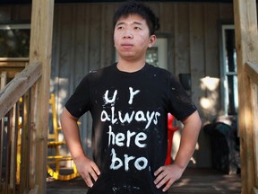 Jinxi Jiang, 20, is pictured Wednesday, Aug. 22, 2012, at the home he shared with Shaowen Zhang, the 25-year-old international student that died in a motor vehicle accident, Tuesday, Aug. 21, 2012.  Jiang is wearing a shirt he made with white paint of a phrase to honour his friend.  (DAX MELMER/The Windsor Star)