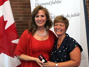 Sandra Pupatello, left, receives the Queen Elizabeth II Diamond Jubilee Medal from Windsor West MPP Teresa Piruzza at the Hiram Walker Wiser's Reception Centre, Saturday, August 25, 2012.  (DAX MELMER/The Windsor Star)