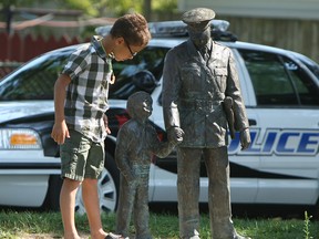 Reece Akpata looks a statue of Alton Parker during a service to commemorate the hiring of Alton Parker at Alton C. Parker park in Windsor on Friday, August 3, 2012. Parker was the first black police officer in Windsor and was hired 70 years ago.         (The Windsor Star / TYLER BROWNBRIDGE)