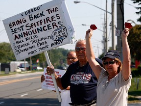 Robert Matis, centre holding sign, Lori Multari, right,  and Jim Allen, behind, join area residents and concerned television viewers for a rally at Cogeco Cable's Dougall Road studios to voice their displeasure with the decision to drop Bill Kelso, Brian Trenholm and Domenic Papa from their Windsor Spitfires broadcasts August 23, 2012. (NICK BRANCACCIO/The Windsor Star)