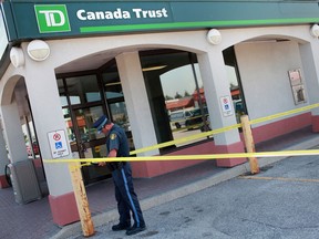 An OPP officer works outside the TD Canada Trust bank in the Green Valley Plaza in Tecumseh, Ont.,  where a robbery occurred outside the building, Thursday, August 30, 2012.  (DAX MELMER/The Windsor Star)