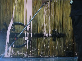 A City of Windsor worker washes pink paint off the front door of the All Saints Church, Monday, Aug. 20, 2012, in downtown Windsor, Ont. The paint was thrown on the door by vandals. (DAN JANISSE/ The Windsor Star)