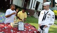 Joshua Smith and Dwayne Durant (right) react after AM1 Robert Wawro presented them with $250 from Detroit area Navy recruiters at Smith's popcorn and lemonade stand in front of his Detroit home on Wednesday, August 2, 2012. Smith has gained national attention for his efforts to raise money to help the cash strapped city of Detroit. Smith says he was hoping the city could use the money to cut the grass at the local parks. (The Windsor Star / TYLER BROWNBRIDGE)