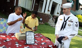 Joshua Smith and Dwayne Durant (right) react after AM1 Robert Wawro presented them with $250 from Detroit area Navy recruiters at Smith's popcorn and lemonade stand in front of his Detroit home on Wednesday, August 2, 2012. Smith has gained national attention for his efforts to raise money to help the cash strapped city of Detroit. Smith says he was hoping the city could use the money to cut the grass at the local parks. (The Windsor Star / TYLER BROWNBRIDGE)