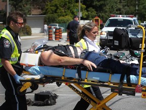 A man is taken away on a stretcher by EMS Paramedics after he was stuck by a minivan while riding a motorcycle at George Avenue and Wyandotte Street East, Monday, Aug. 6, 2012. (DAX MELMER/The Windsor Star)