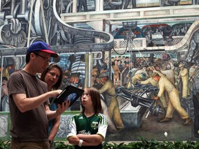 Brian Martin 41, Karen Martinek, 42, and Emma Martin, 11, from Portland ,Oregon use the interactive device to learn about the Diego Rivera mural at the Detroit Institute of Arts in Detroit, Mich.,Thursday, July 19,  2012. They have Detroit roots and are visiting family in the area. SUSAN TUSA/Detroit Free Press