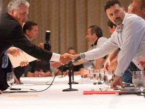 Chrysler Canada's Glenn Gorick, left, shakes hands with Dino Chiodo, chairperson of the CAW's Chrysler master bargaining committee, as Chrysler opens contract talks with the union in Toronto on Aug. 14, 2012. (Michelle Siu/THE CANADIAN PRESS)