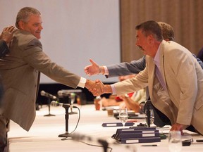 David Wenner, left, general director of labour relations for General Motors, shakes hands with Chris Buckley, chairperson of the CAW's GM master bargaining committee, in Toronto on Aug. 14, 2012. (/Michelle Siu/THE CANADIAN PRESS)
