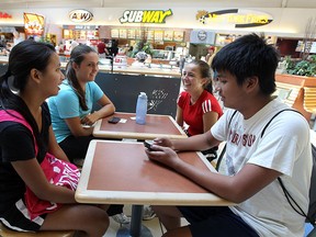 Kyrsten Villacorte, left, Meighan Cassidy, Jacqueline Cassidy and Lawrence Villacorte sit in the food court at Tecumseh Mall in Windsor.