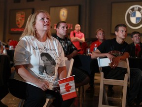Cathy Diemer, left, sits stunned among a crowd of fans as they watch Canadian boxer Mary Spencer lose in her first Olympic match, Monday, August 6, 2012.  A large crowd gathered at Drive Logistics in Windsor, Ont., to watch the match.
