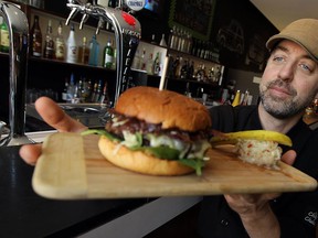 Jay Soulliere, owner of Motor Burger, proudly displays one of the hamburgers that got Motor Burger the Reader's Digest pick for best burger in Canada in May 2012. But for the editors of Macleans Magazine, Windsor's restaurants don't rate a mention in its list of the 50 best restaurants in Canada. (TYLER BROWNBRIDGE / The Windsor Star)