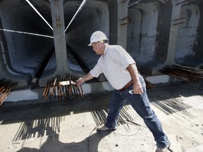 Loris Collavino, owner of Prestressed Systems Inc. inspects some of 546 concrete and steel bridge girders on Friday to be used on The Windsor-Essex Parkway,  under the roadbed. (NICK BRANCACCIO/The Windsor Star)