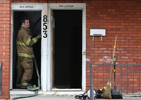 A Windsor firefighter cleans up after an arson in the 800 block of Pillette Road on Sunday, April 1, 2012. (Dax Melmer/The Windsor Star)