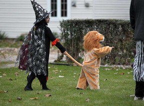 In this file photo, hungry lion Landon Dimitroff, 2, right, has his tail pulled by his sister Abby Dimitroff, 7, while visiting neighbours on Eastlawn Boulevard. Halloween night Monday, Oct. 31, 2011, in Windsor, Ont. Landon was heading toward the front door where Fran Robich was handing out tasty treats.  (NICK BRANCACCIO/The Windsor Star)