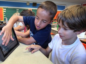 Grade four students Alex Rafael-Rawlings, centre left, and Nick Putt use an IPad while working with teacher Lori Market, September 12, 2012. The use of IPads as a teaching tool has been one of the key elements of higher test scores at the Windsor elementary school. (NICK BRANCACCIO/The Windsor Star)