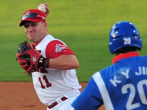 Windsor's Stubby Clapp, left, throws to first base in front of South Korea's Jin Kabyong during the 2008 Beijing Olympic Games (Frederic J. Brown/AFP photo)