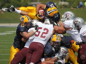 Lancers running back Mitch Dender, top, scores at the goal line in the season opener against the Ottawa Gee-Gees at Alumni Field. (DAX MELMER/The Windsor Star)