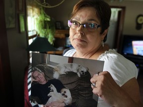 Barb Fuller holds a photo of her husband Clancy in their Kingsville home recently. Clancy remains in a London hospital recovering from a heart transplant.