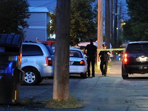 Edmonton police officers study an alley behind an apartment building where 25-year-old Bogdan Pamfil -- a former Windsor resident -- was found shot dead on Sept. 4, 2012. (John Lucas / Edmonton Journal)