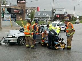 Paramedics remove a woman from a Chevrolet Cavalier following a collision with a service van at Jefferson Avenue and Quality Way on Tuesday, Sept. 18, 2012. (NICK BRANCACCIO/The Windsor Star)