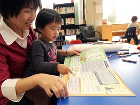 Alana Yu gets some help from her mother Lijuan Zhang while reading at the downtown library branch in Windsor on Tuesday, September 11, 2012. (TYLER BROWNBRIDGE/The Windsor Star)