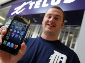 Trevor Starling proudly displays his brand new iPhone 5 outside of the Telus store at the Devonshire Mall in Windsor on Sept.21, 2012.(TYLER BROWNBRIDGE / The Windsor Star)