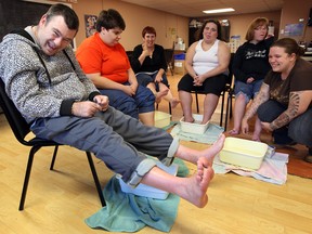Kevin Renaud, left, joyfully raises his feet out of the water after participating in a foot bath relaxation activity at Reach for the Skye Windsor, a day program for adults with developmental challenges on October 2, 2012. Joining Kevin were Ristina Stojcevski, 2nd left, Tawni Hodgins, Eva Kozlowska, Nicole Markham and supervisor Michal Kozma, right. (NICK BRANCACCIO/The Windsor Star)