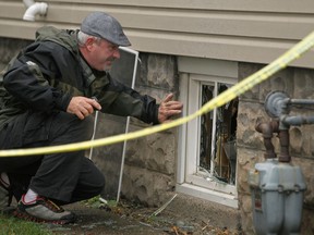 Windsor police Det. Glenn Gervais investigates the scene of late-night house fire at 536 Cameron Ave., Sunday, Oct. 14, 2012. The fire is being treated as arson.   (DAX MELMER/The Windsor Star)