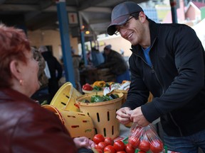 Rob Buchard, right, of Buchard Gardens in Harrow, sells tomatoes on the last day of the season for the Downtown Farmer's Market in Windsor on Saturday, Oct. 6, 2012. (DAX MELMER/The Windsor Star)