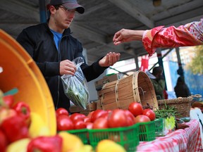 Rob Buchard, left, of Buchard Gardens in Harrow, sells local produce on the last day of the season for the Downtown Farmer's Market in Windsor in this 2012 file photo. (DAX MELMER/The Windsor Star)
