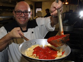 Enzo Mancuso of Enzo's Trattoria on Erie Street East ladles his zesty, homemade tomato sauce on a plate of pasta Wednesday October 10,  2012.  (NICK BRANCACCIO/The Windsor Star)