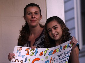 Olivia Christian, 9, with her mother Vanessa Christian and poster for Girl Power Day Friday October 12, 2012.  (NICK BRANCACCIO / The Windsor Star)