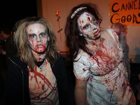 Zombie nurse Amanda Leonard, left, joins with zombie bride Frances Roberts, right, and hundreds of others in Windsor Zombie Walk 2012 on Ouellette Avenue Friday October 12, 2012. The annual event results in thousands of donations of canned goods for the Windsor Homes Coalition Food Bank.  (NICK BRANCACCIO/The Windsor Star)