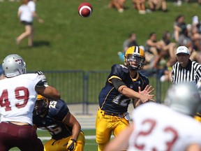 Lancers quarterback Austin Kennedy, right, throws a touchdown pass against the Ottawa Gee-Gees at Alumni Field. (DAX MELMER/The Windsor Star)