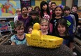 Students at Princess Elizabeth Public School in Windsor, Ont. learn about a model boat carved out of wood which was found at Point Pelee by the husband of their teacher, Glen Gervais.   The boat has been floating on Lake Erie for 17 years and will be relaunched in the Detroit River under the supervision of their teacher Vinka Gervais.  (NICK BRANCACCIO/The Windsor Star)