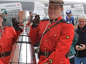 The Grey Cup 100 Train pulled into Windsor, Ont. Tuesday, Oct. 30, 2012, to a large crowd of Canadian Football League fans. RCMP Const. Cory Noseworthy, left, and Const. Jeff Town of the Windsor detachment ceremoniously carried the Grey Cup into the VIA Rail station where a ceremony was held.   (DAN JANISSE/The Windsor Star)