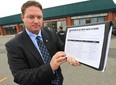 Essex MPP Taras Natyshak is launching a "MPPs Back to Work" campaign. He displays a petition Tuesday, Oct. 23, 2012, that he is encouraging people to sign. He spoke to the media in front of MPP Dwight Duncan's office in Windsor, Ont. (DAN JANISSE/The Windsor Star)