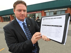 Essex MPP Taras Natyshak is launching a "MPPs Back to Work" campaign. He displays a petition Tuesday, Oct. 23, 2012, that he is encouraging people to sign. He spoke to the media in front of MPP Dwight Duncan's office in Windsor, Ont. (DAN JANISSE/The Windsor Star)