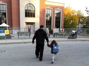 Parents drop off their children at King Edward Public School on Chilver Road in Windsor, Ont., Thursday October 4, 2012. In photo, Cody Northgrove holds the hand of his daughter Shyla on their way across the drop off driveway at King Edward. (NICK BRANCACCIO/The Windsor Star)